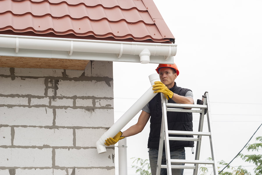man working at the top of the house